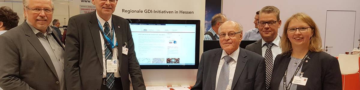 Udo Stichling (Präsident des Deutschen Dachverbands für Geoinformation, DDGI) und Dr. Hansgerd Terlinden (Präsident des Hessischen Landesamtes für Bodenmanagement und Geoinformation, HLBG) (von links) waren am Messestand zu Gast und erhielten beim Vortrag von Christiane Müller (Projektleiterin im Amt für Bodenmanagement Fulda) und Udo Harzer (Geschäftsführer GDI Vogelsberg) einen Überblick über die Möglichkeiten des Geoportals Vogelsbergkreis. Dahinter stehend: Alf Sobieray, Abteilungsleiter