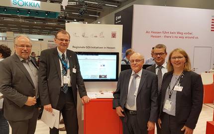 Udo Stichling (Präsident des Deutschen Dachverbands für Geoinformation, DDGI) und Dr. Hansgerd Terlinden (Präsident des Hessischen Landesamtes für Bodenmanagement und Geoinformation, HLBG) (von links) waren am Messestand zu Gast und erhielten beim Vortrag von Christiane Müller (Projektleiterin im Amt für Bodenmanagement Fulda) und Udo Harzer (Geschäftsführer GDI Vogelsberg) einen Überblick über die Möglichkeiten des Geoportals Vogelsbergkreis. Dahinter stehend: Alf Sobieray, Abteilungsleiter